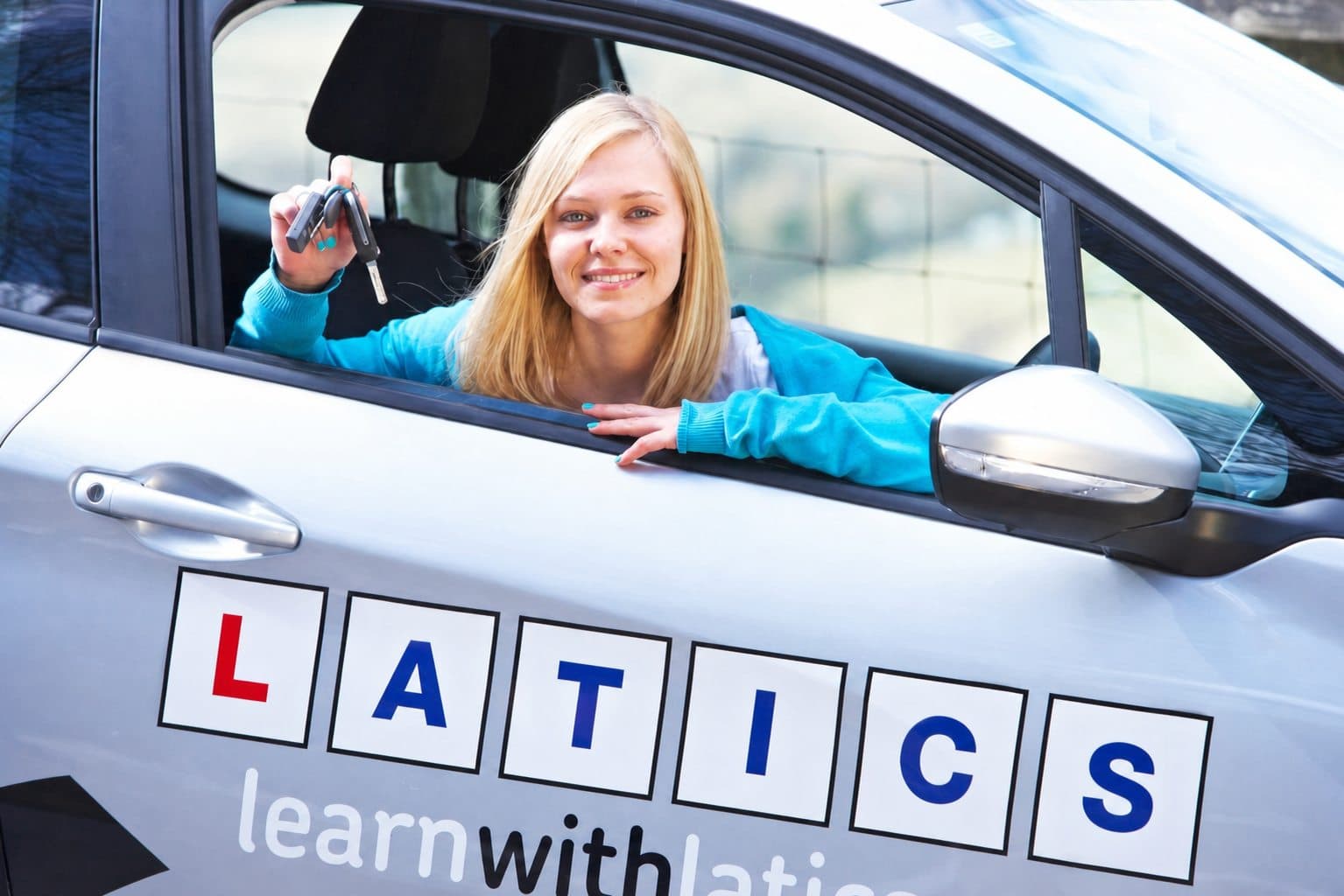 Learner driver smiling in the wing mirror during a Latics driving lesson